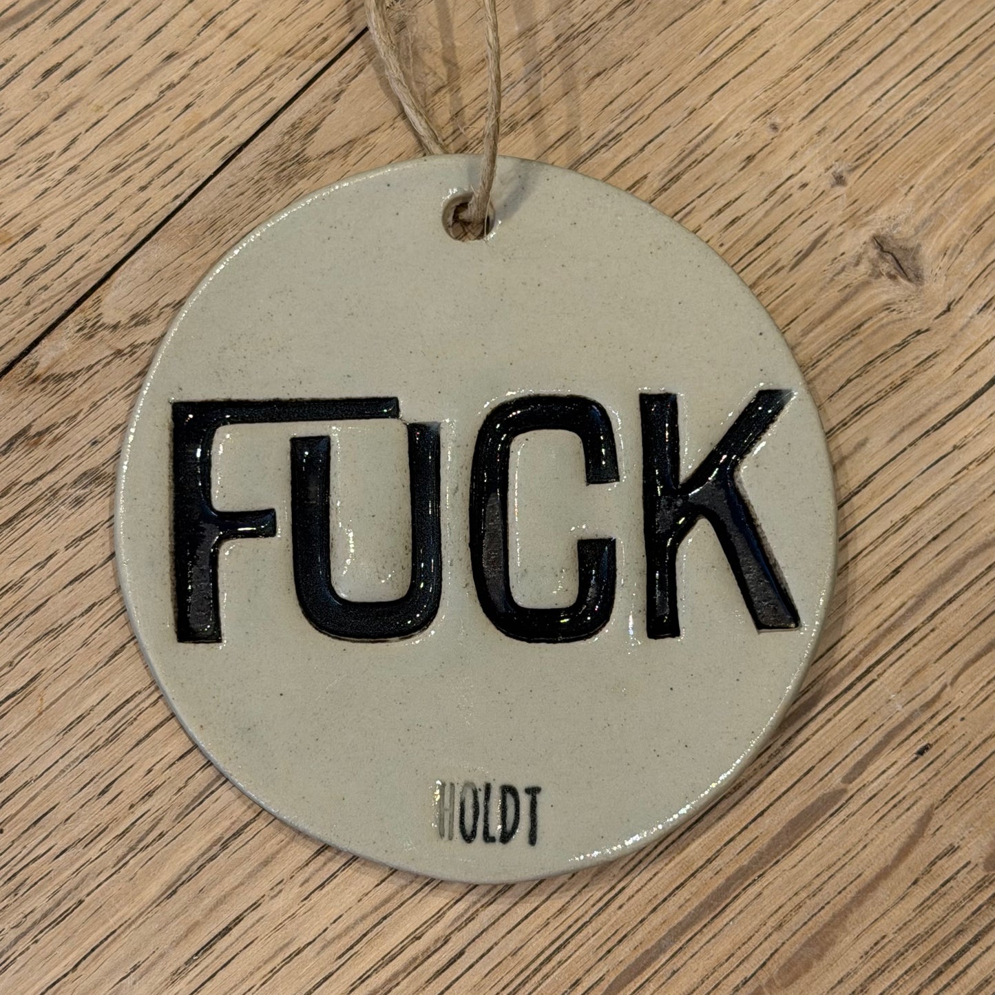 Ophæng med tekst; ‘FUCK’
