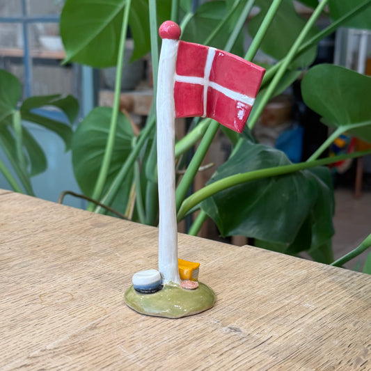 Flagstang med Dannebrog, studenterhue, lys blå