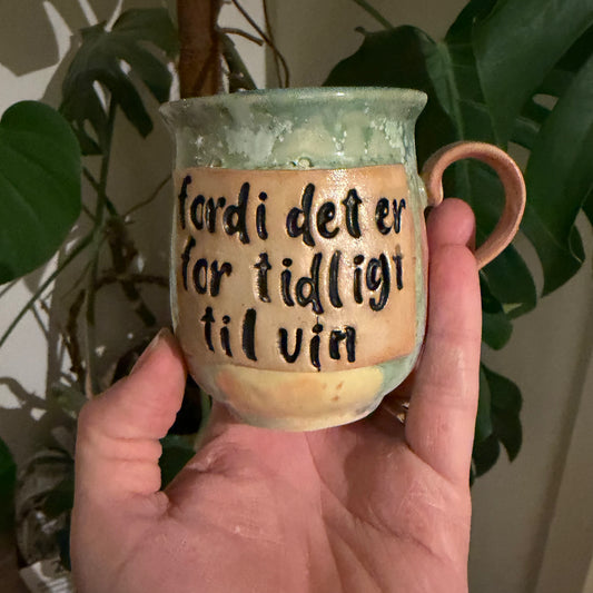 Håndlavet kop med hank og tekst; fordi det er for tidligt til vin