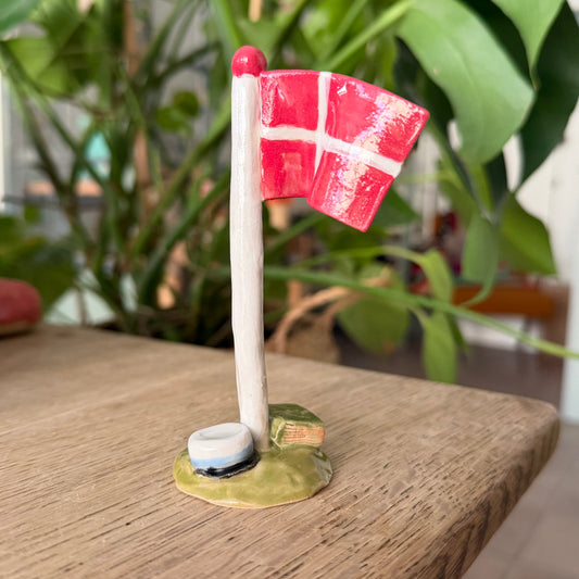 Flagstang med Dannebrog, studenterhue, lys blå