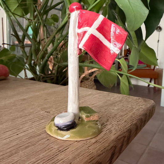 Flagstang med Dannebrog, studenterhue, lilla