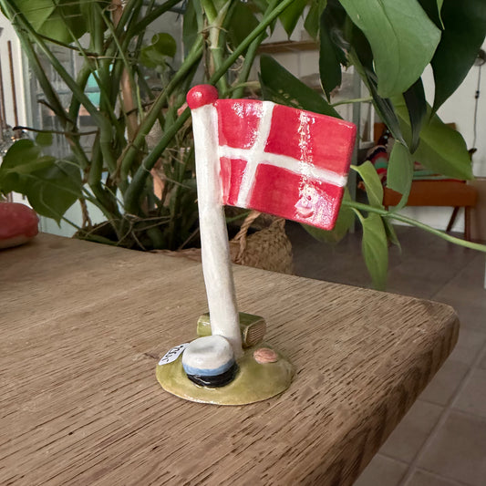 Flagstang med Dannebrog, studenterhue, lys blå