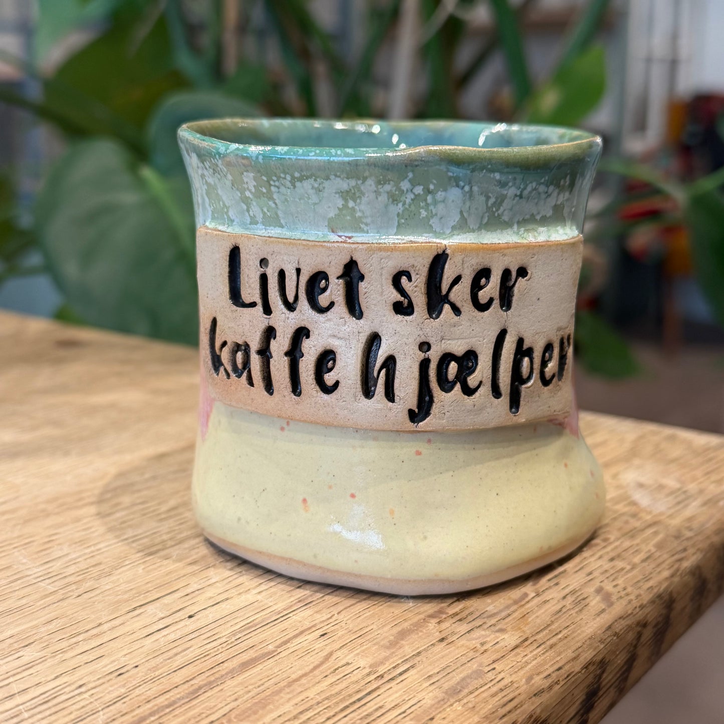 Håndformet krus med tekst; Livet sker, kaffe hjælper