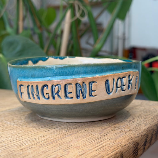 Skål med tekst «FINGRENE AV»