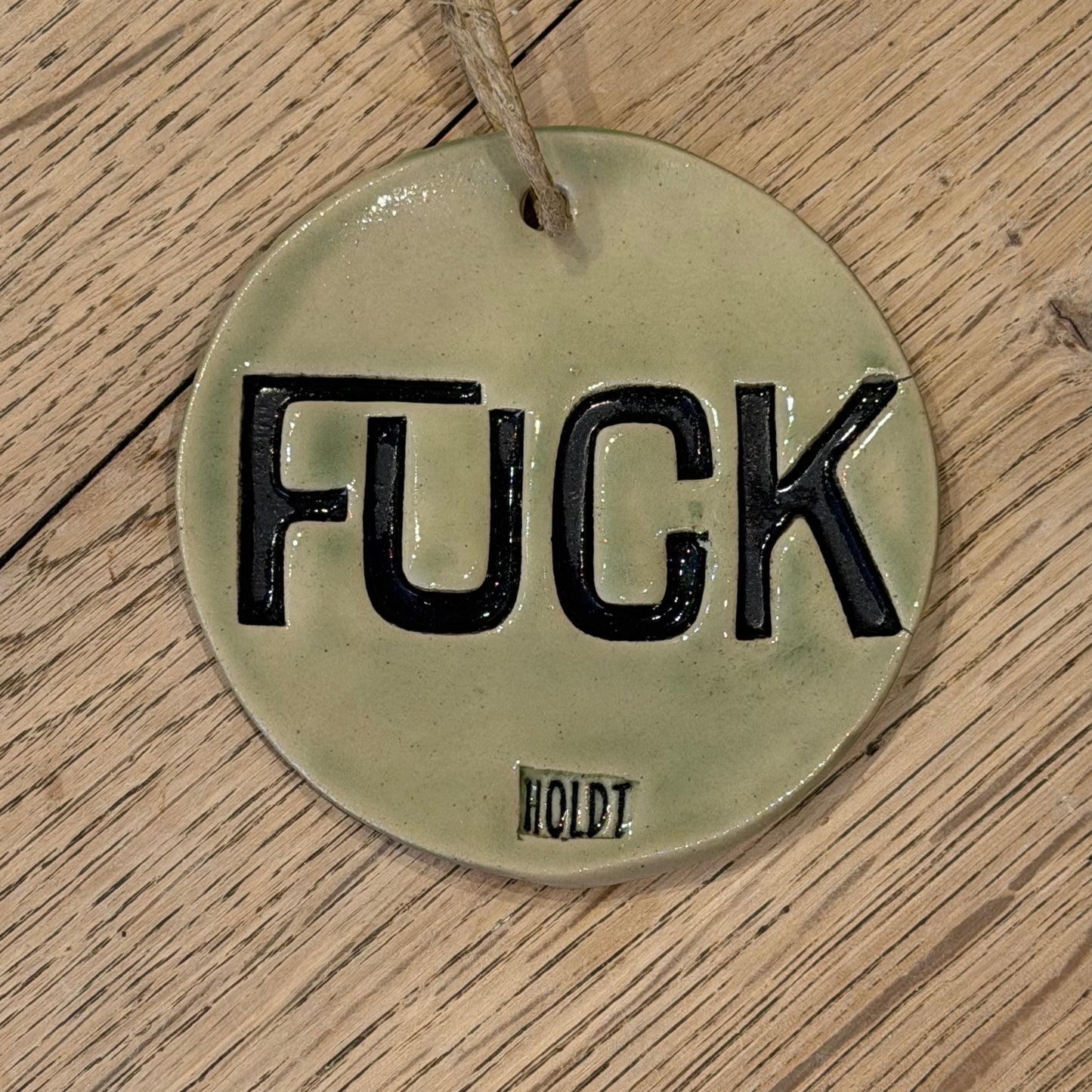 Ophæng med tekst; ‘FUCK’, lys grøn